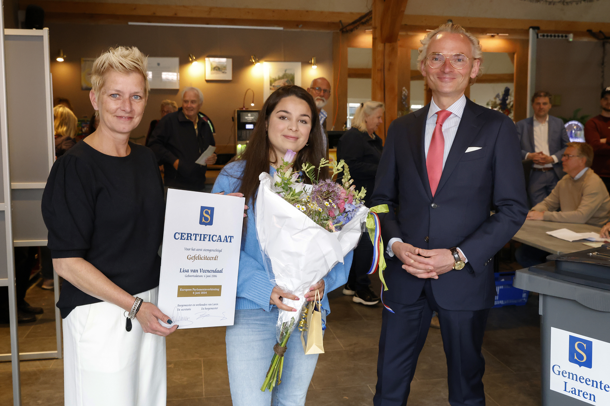 Een foto van burgemeester Nanning Mol, projectleider Petra van Dijk en de jongste stemmer uit Laren, Lisa van Veenendaal.